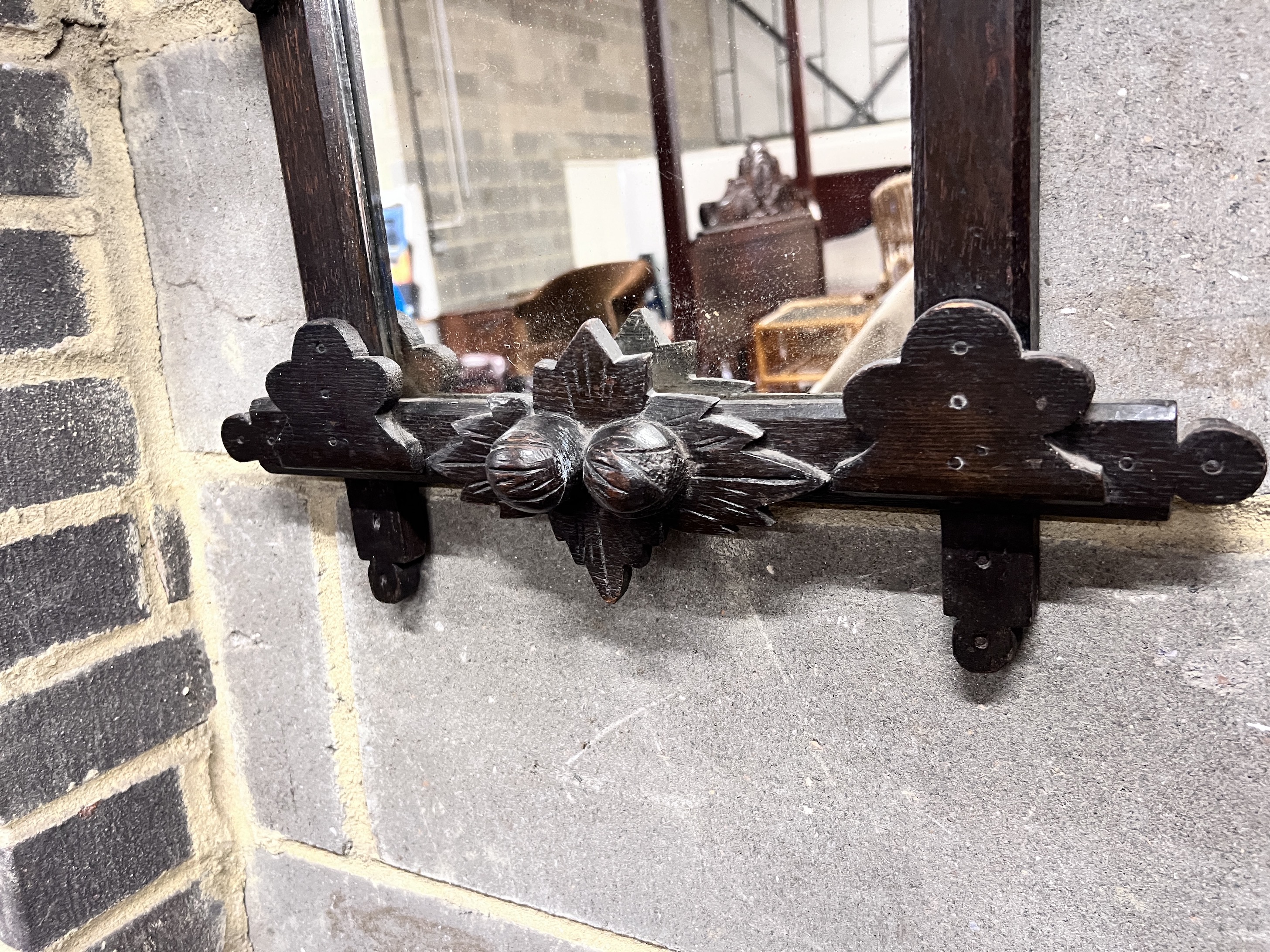 A late 19th century Black Forest ebonised oak wall mirror with eagle surmount, width 46cm, height 65cm